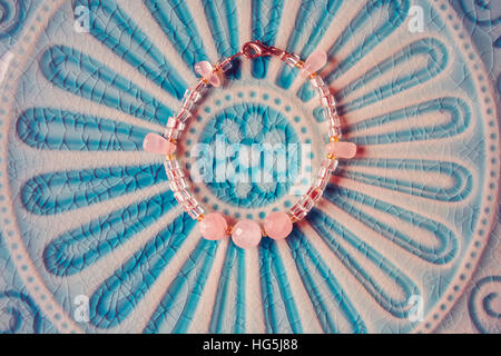 Yoga bracelet placed on turquouise plate Stock Photo