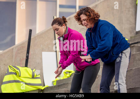 Theatre education in the UK: Two Aberystwyth university theater studies undergraduate women students performing a devised outdoor site-specific drama on location outside Aberystwyth Arts Centre, Wales UK Stock Photo