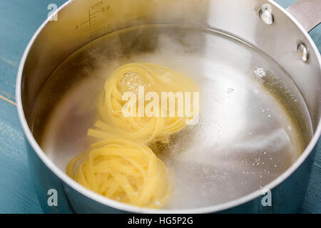 Adding Tagliatelle Pasta In Hot Water Pot For Boil Stock Photo