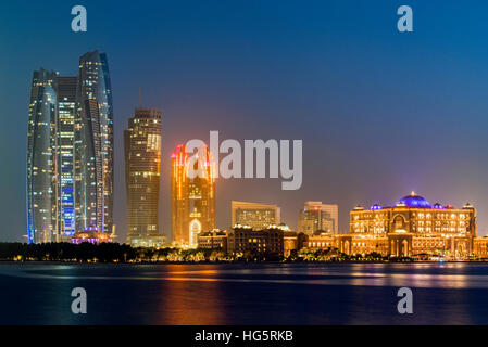 CIty skyline at twilight with Etihad Towers and Emirates Palace Hotel, Abu Dhabi, United Arab Emirates Stock Photo
