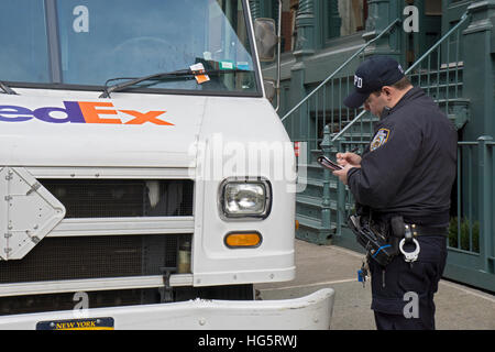 A policeman writing a parking ticket for a Fedex truck in the Soho section of lower Manhattan, New York City Stock Photo