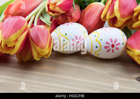 Painted Easter eggs and red and yellow tulips Stock Photo