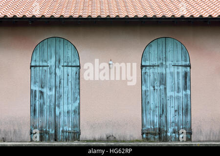 Close up of old wooden blue door in brick wall Stock Photo