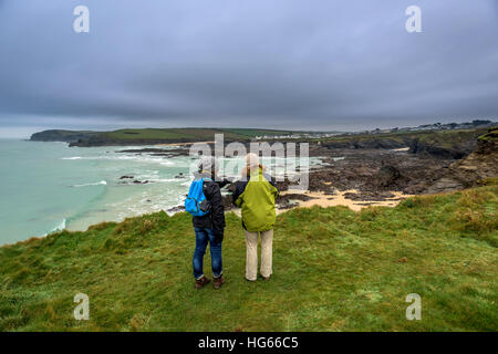 Two women look out over Newtrain Bay in Trevone, Cornwall Stock Photo