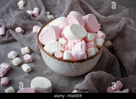 White and pink marshmallows on gray concrete background. Selective focus Stock Photo