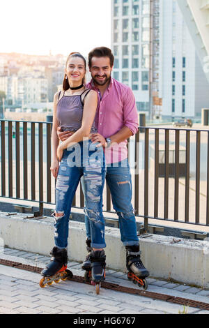 Couple on rollerblades smiling. Stock Photo