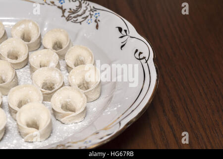 Homemade uncooked uszka traditional ukrainian dumplings filled with mushrooms for Christmas Stock Photo