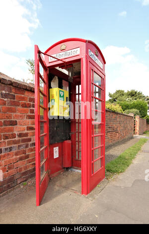 An old red British telephone box in Cossall Village, Nottingham, UK. Now converted into an emergency defibrillator station. Stock Photo