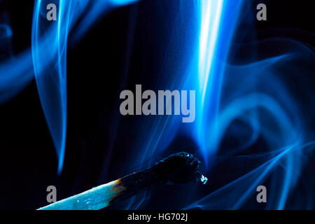 Burning match on a black background Stock Photo