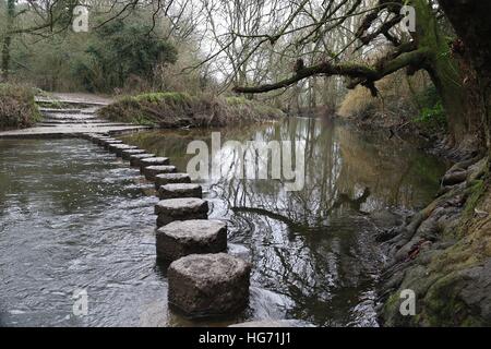 Stepping stones across a cold river in winter Stock Photo