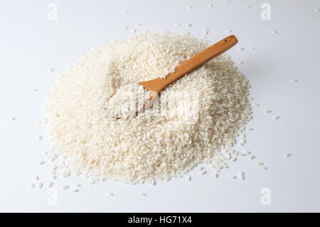 Wooden spoon in pile of rice on white background Stock Photo