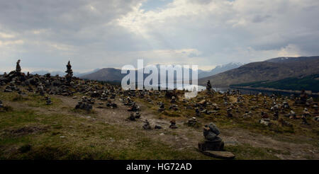 Scenic view of mini cairns at loch loyne Skye. Sun rays and mountains in the background. Stock Photo