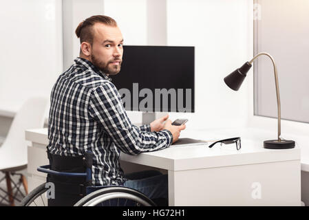 Young physically challenged person working in home office Stock Photo