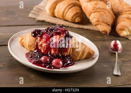 Croissant with jam on the table in natural light Stock Photo