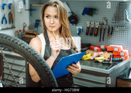 Thoughtful craftswoman taking notes in the workshop Stock Photo
