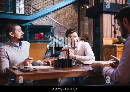 Handsome pleasant man holding a menu Stock Photo