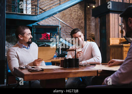 Pleasant nice man pointing at his friend Stock Photo