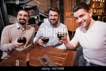 Handsome nice men raising glasses with beer Stock Photo