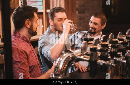 Joyful attractive man drinking beer Stock Photo