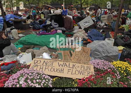 Morning in the Occupy Wall Street protester camp at Zuccotti Park. A placard protects the park's flowers. Stock Photo