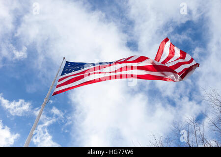 An American Flag blows in the wind with a beautiful sky Stock Photo