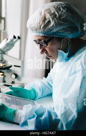 Side view of scientist working on tablet Stock Photo