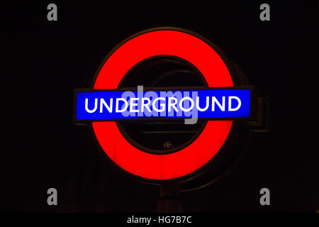 Illuminated London underground roundel tube sign at night Stock Photo