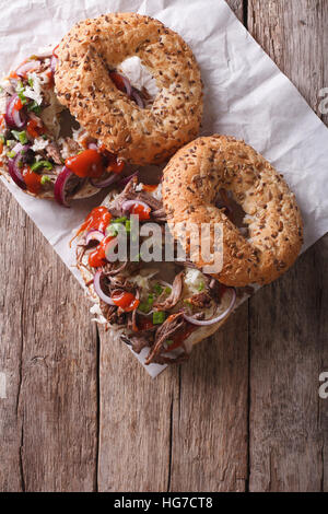 Bagels with Pulled pork, onions, cabbage and sauce on the table. vertical top view Stock Photo