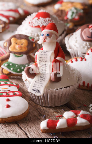 Christmas cupcakes and gingerbread cookies macro on a wooden table. Vertical Stock Photo