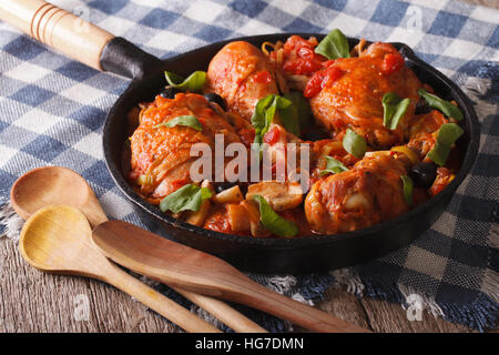 Italian cuisine: Chicken Cacciatori with mushrooms close up in a frying pan. Horizontal Stock Photo