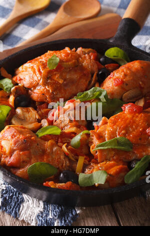 Italian food: chicken with tomato and vegetables close-up in a frying pan. Vertical Stock Photo