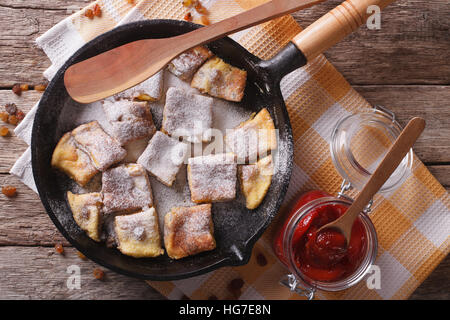 Delicious omelette Kaiserschmarrn with plum sauce close-up on a frying pan. Horizontal top view Stock Photo