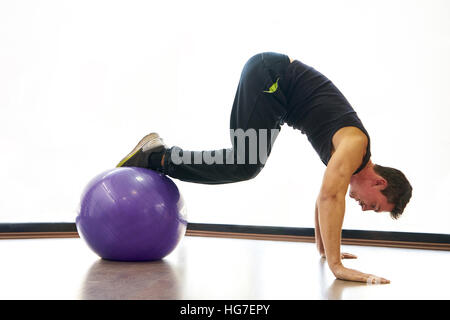 Athletic man exercising with ball in gym Stock Photo