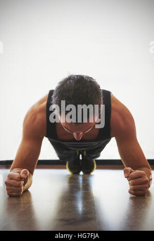 Fit young man doing pushups in a gym Stock Photo