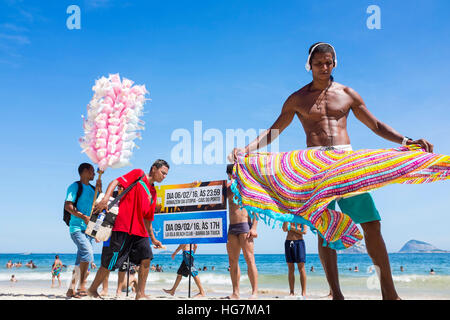 RIO DE JANEIRO - JANUARY 05, 2016: Beach vendors and sunbathers share a bright day on Ipanema Beach. Stock Photo