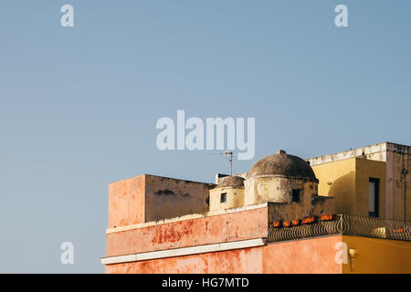 An old, pastel-coloured building against a clear blue sky on the island of Ventotene, off the coast of Lazio near Rome. Stock Photo