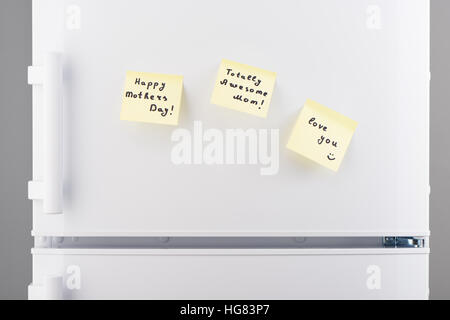 Totally awesome Mom, Happy Mothers Day, love you notes on light yellow sticky paper on white refrigerator door Stock Photo