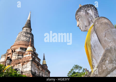 Buddha statue and ancient pagoda on blue sky background at Wat Yai Chaimongkol temple in Phra Nakhon Si Ayutthaya Historical Park, Ayutthaya Province Stock Photo