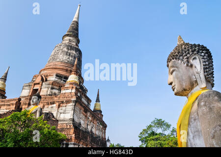 Buddha statue and ancient pagoda on blue sky background at Wat Yai Chaimongkol temple in Phra Nakhon Si Ayutthaya Historical Park, Ayutthaya Province Stock Photo