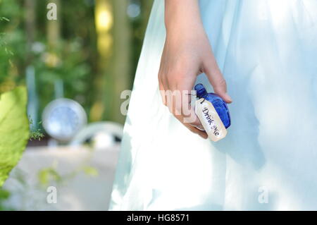 Drink me. Alice in Wonderland. Girl in blue dress Stock Photo