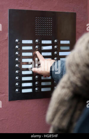 finger pressing door bell at apartment building Stock Photo