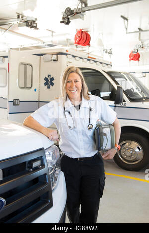 Portrait of female EMT standing by ambulance Stock Photo
