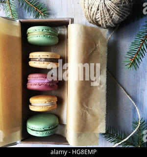 Overhead view of macaroons arranged in box with string and twigs on table Stock Photo