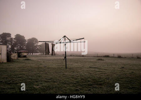 towels hang from a clothesline in foggy mist in dawn Stock Photo