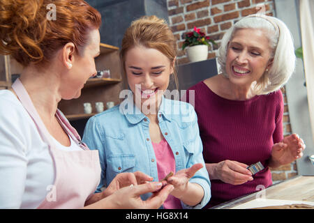 Happy family of three generations preparing gingerbread cookies at home Stock Photo