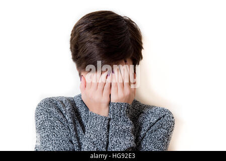 Young woman portrait, desperate with hands covering her face, isolated on white background Stock Photo