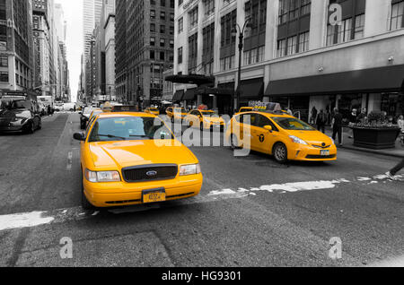 NEW YORK - APRIL 28, 2016: Typically yellow medallion taxicabs in front of Macy's department store. They are widely recognized icons of the city and c Stock Photo