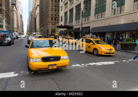 NEW YORK - APRIL 28, 2016: Typically yellow medallion taxicabs in front of Macy's department store. They are widely recognized icons of the city and c Stock Photo