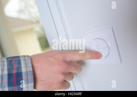 Man controlling the central heating thermostat Stock Photo