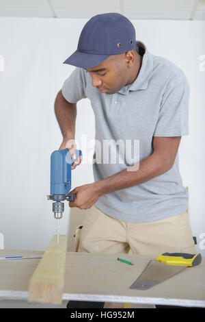 Man drilling into piece of wood Stock Photo